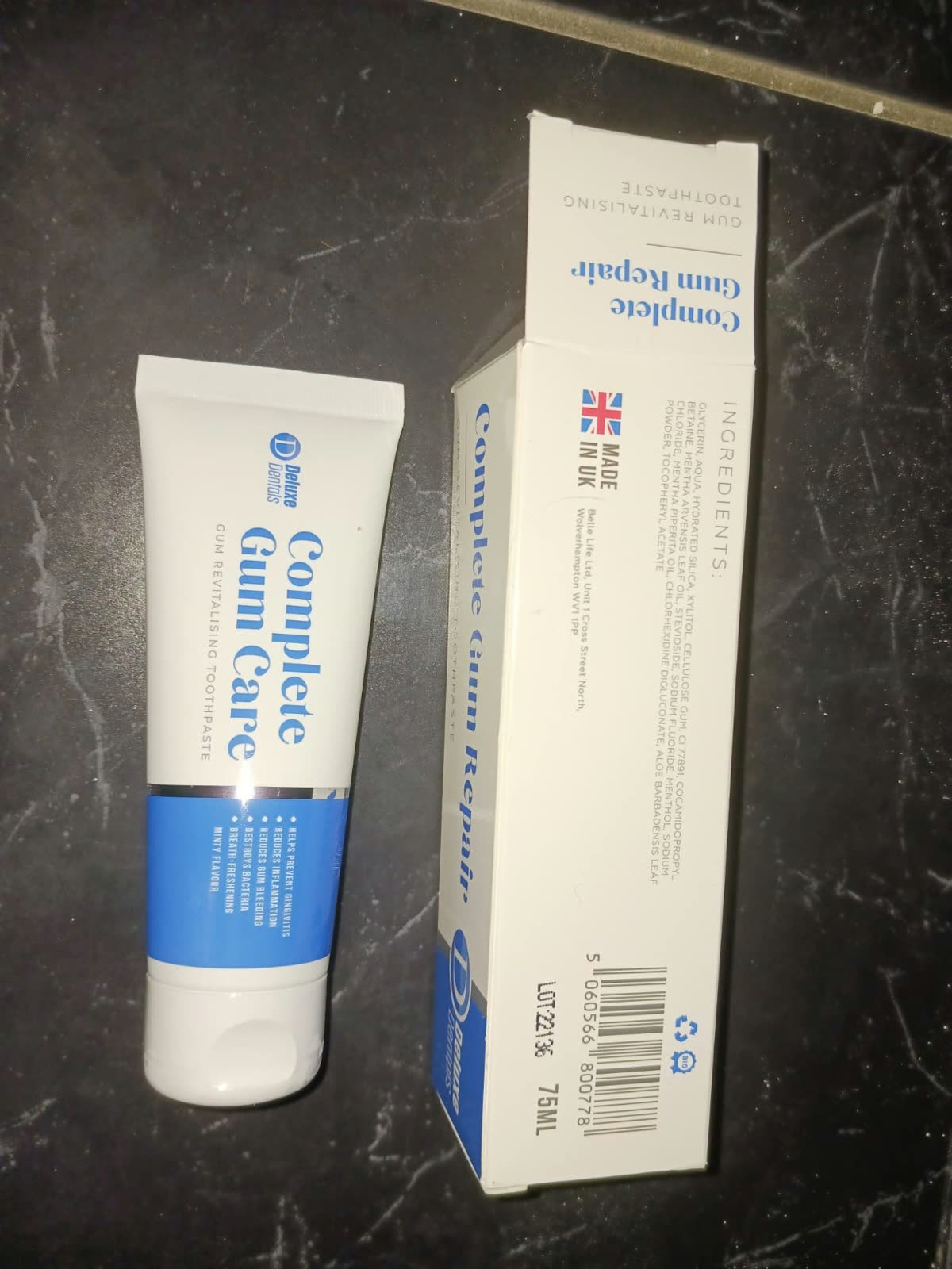 Complete Gum Care toothpaste tube and box laid flat on a dark surface.